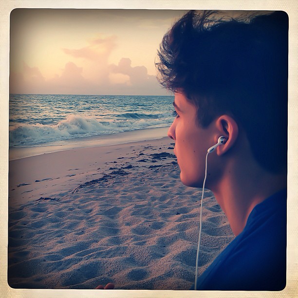 a person on a beach with ear buds in their ears