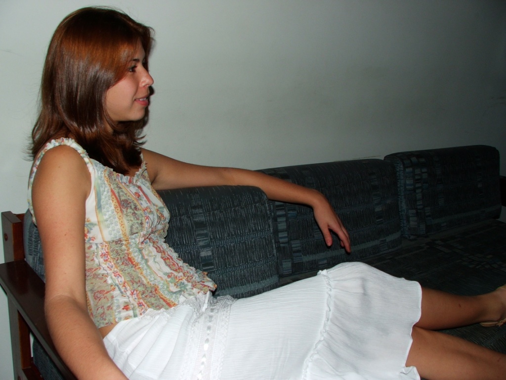the woman is sitting on a couch, staring away from the camera