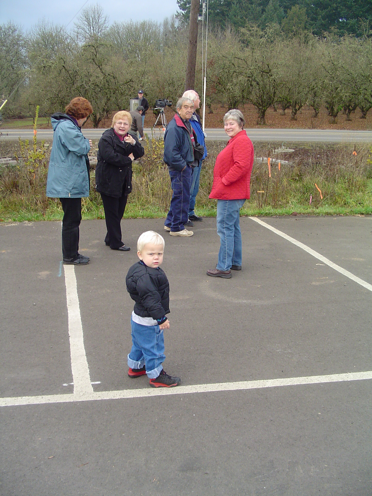 several people with little children standing in the parking lot