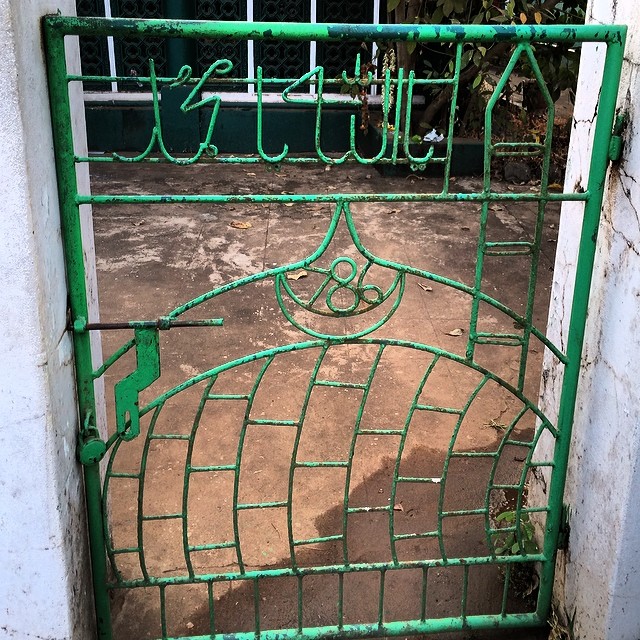 there is a metal green gate with leaves