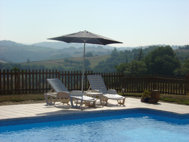 a swimming pool with chairs and an umbrella