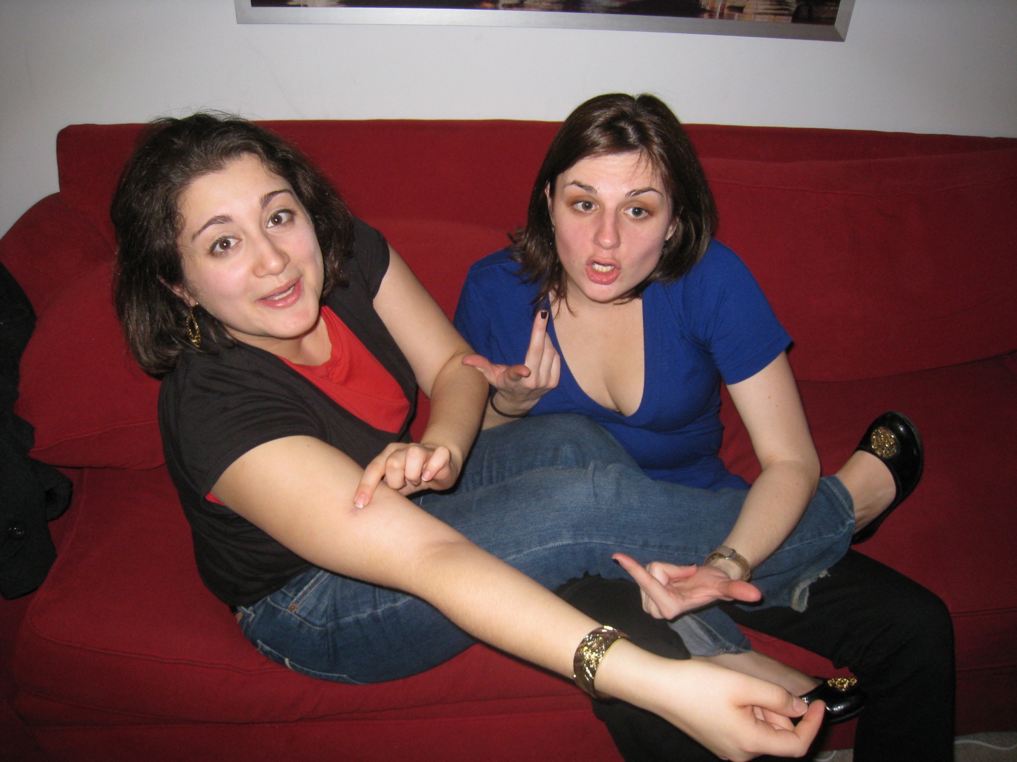 a girl is sitting on the couch with another girl