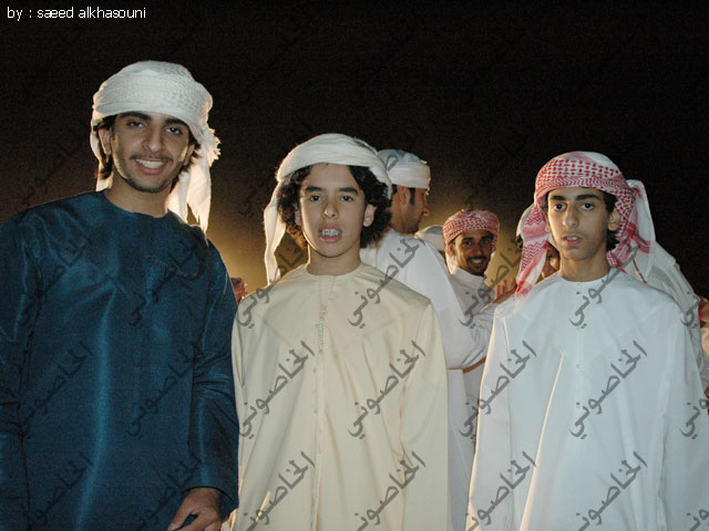 people standing outside at night wearing traditional attire