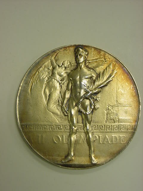 a golden medal that is placed on a white wall