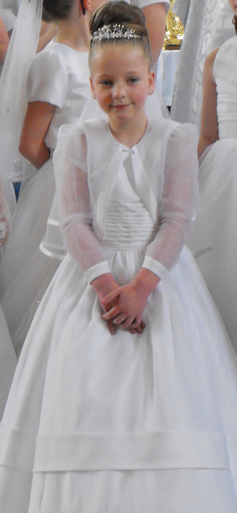 a little girl wearing a white dress standing next to a wedding couple