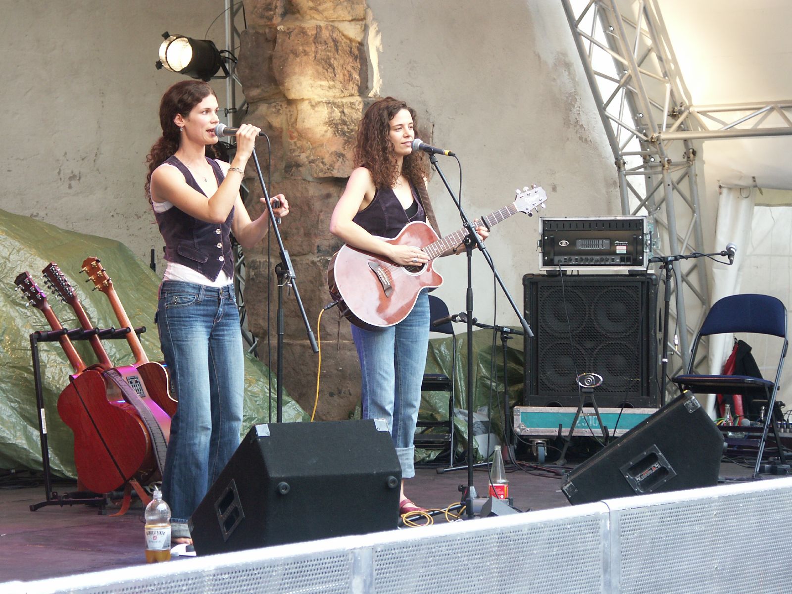 two girls sing with guitars and sing into the microphone