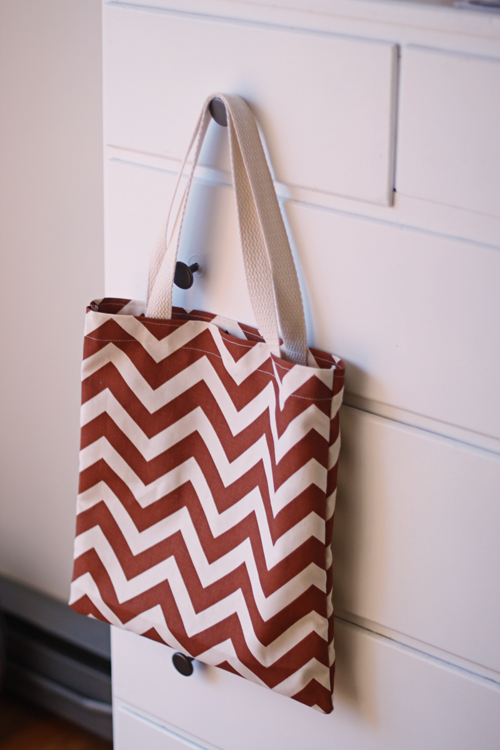 a small brown and white bag hanging on a white wall