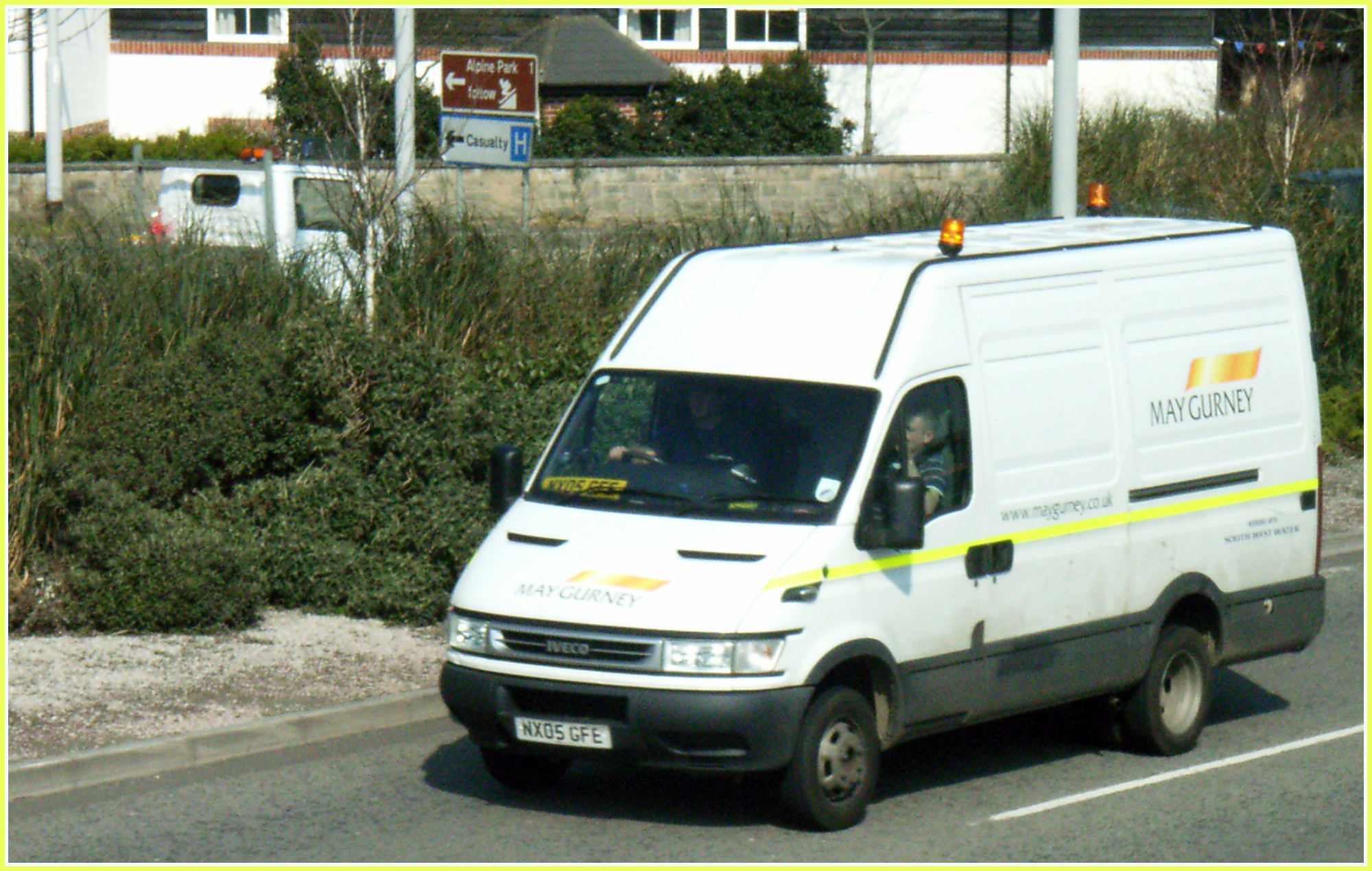 a van driving on a city street, with yellow tape in the side