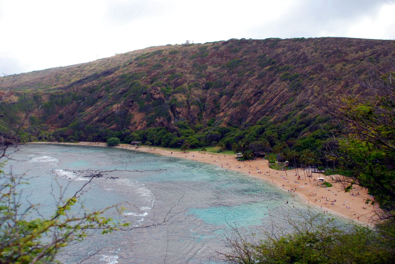 a view of a blue - colored beach from a hill top