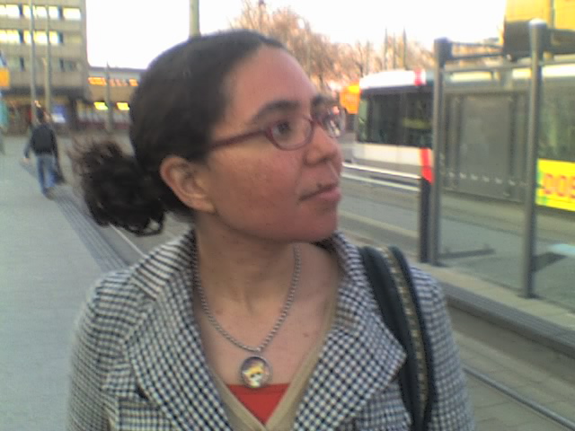 a woman with glasses walking down the sidewalk