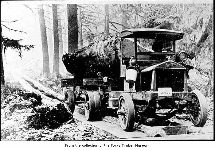 an old po shows an antique truck carrying logs