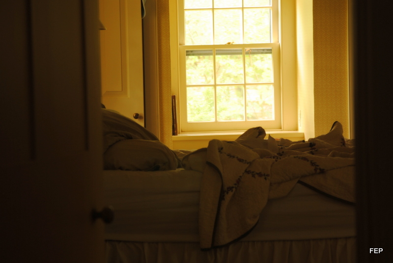 an open window with towels laying on the bed