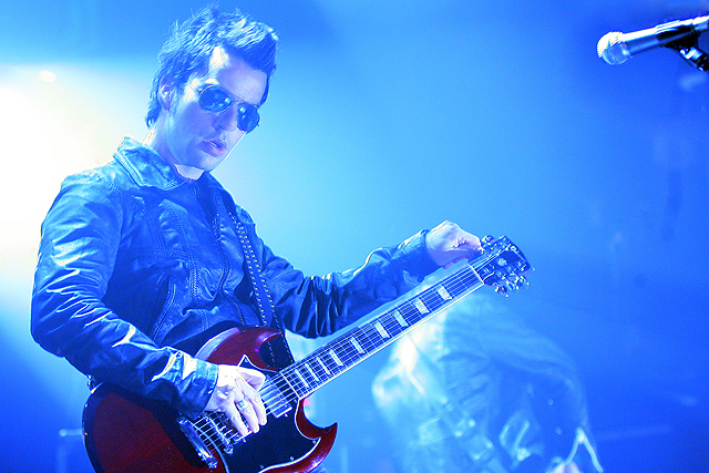 a man with sunglasses playing an electric guitar