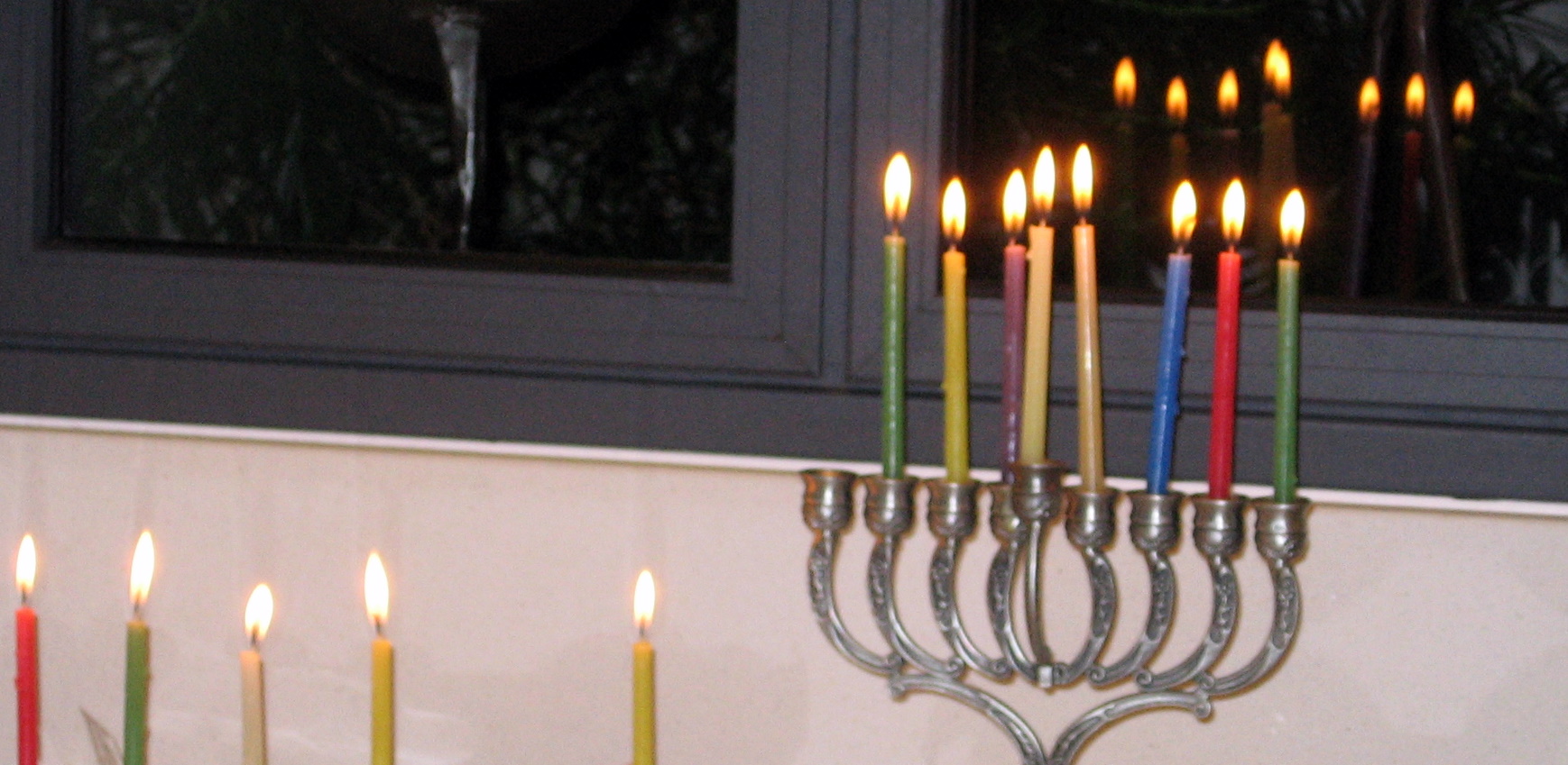 a chandelier is decorated with many lit candles