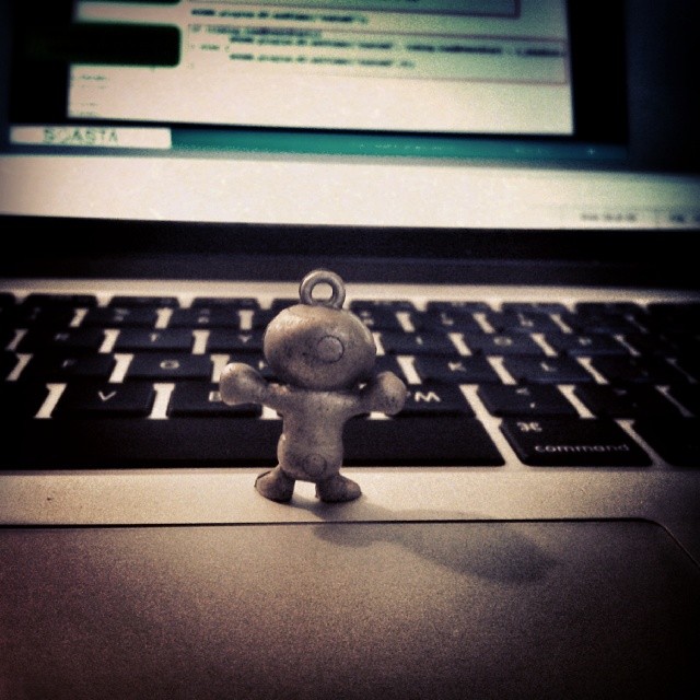 an old toy sitting on top of a computer keyboard