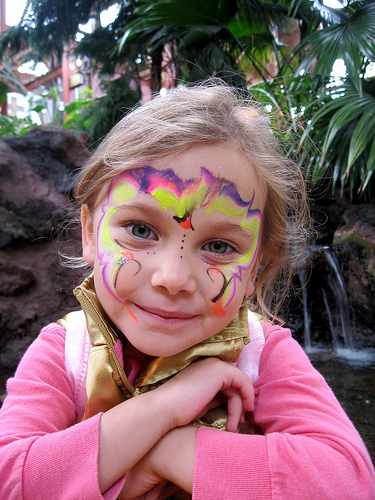 a girl with face paint holding her hands together