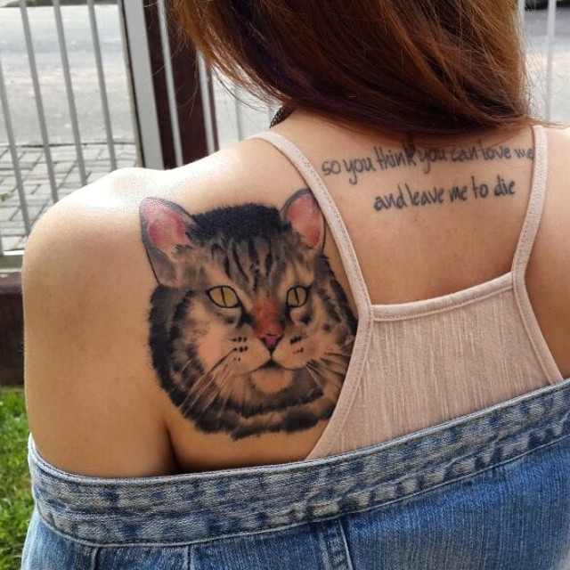 the back of a woman with a cat tattoo