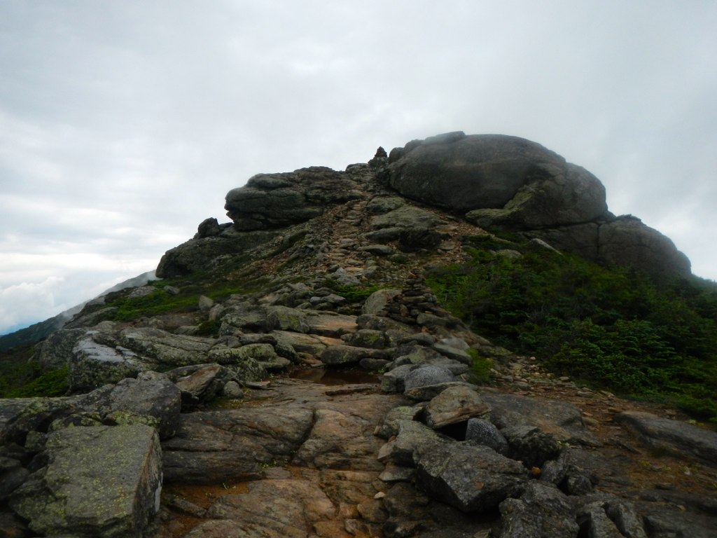 a large rock is on top of a steep hill