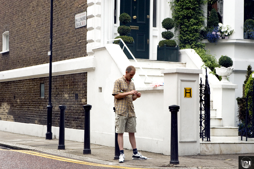 a man in a on down standing near the street