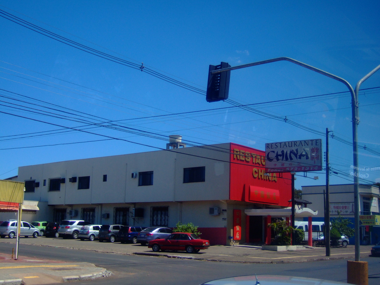 a business sits at an intersection with cars parked nearby