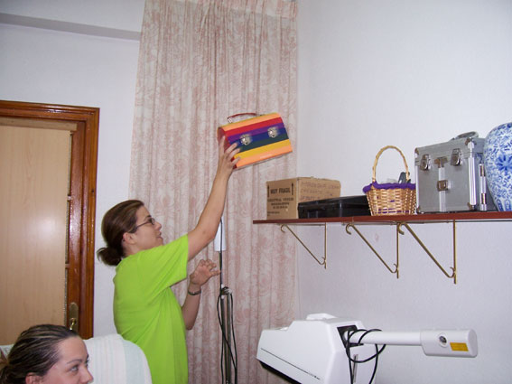 woman cleaning wall of el room area with electric fan
