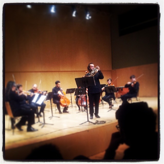 a conductor is standing in front of orchestra players