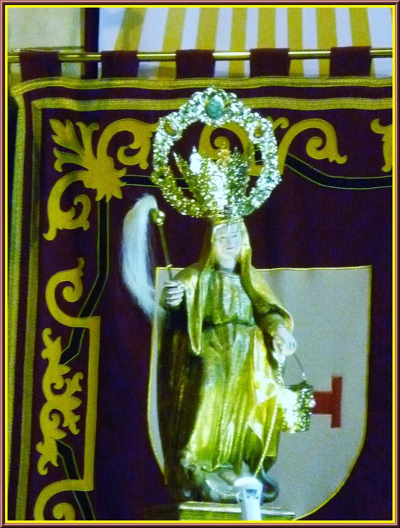 a statue of a person wearing a crown with a cross