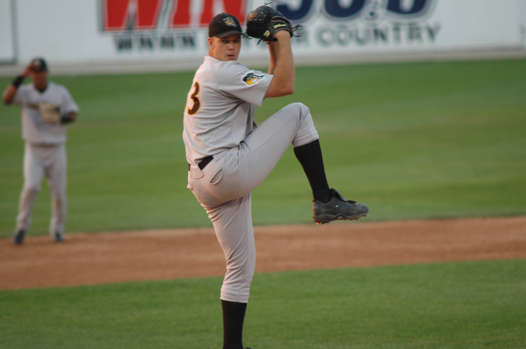 a man wearing a uniform and black hat on top of a field