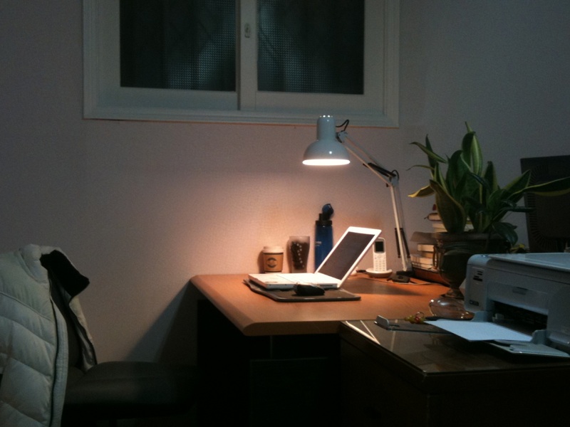 a laptop is on a desk under a light