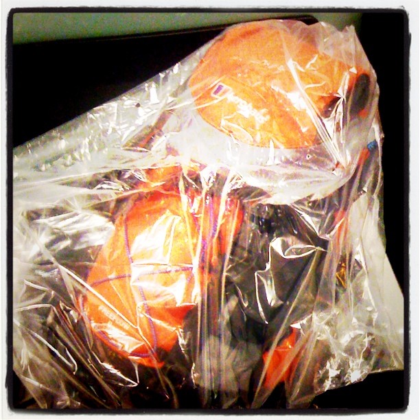 oranges wrapped in plastic sitting on top of a table
