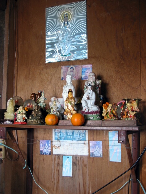 the mantle has many small buddha statues and other items