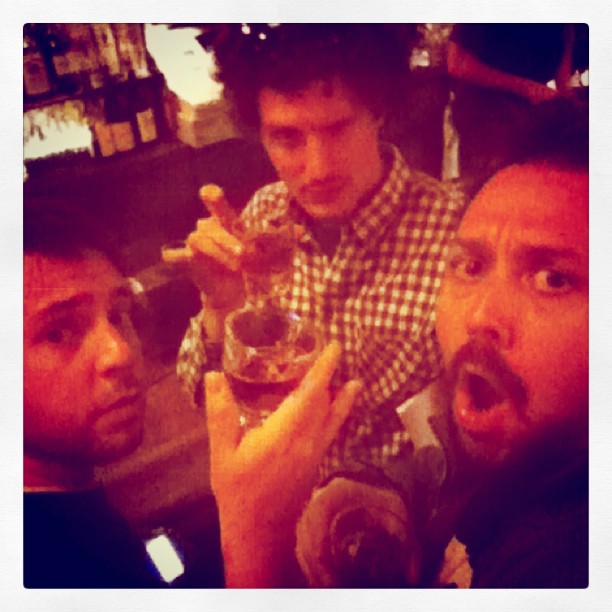 men in plaid shirts and mustaches holding wine glasses