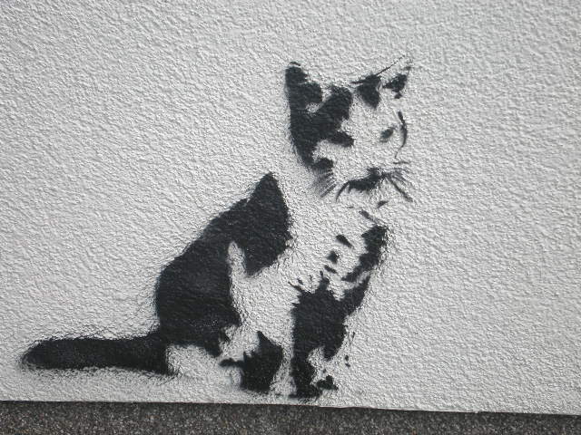 a cat is sitting on the side of a wall