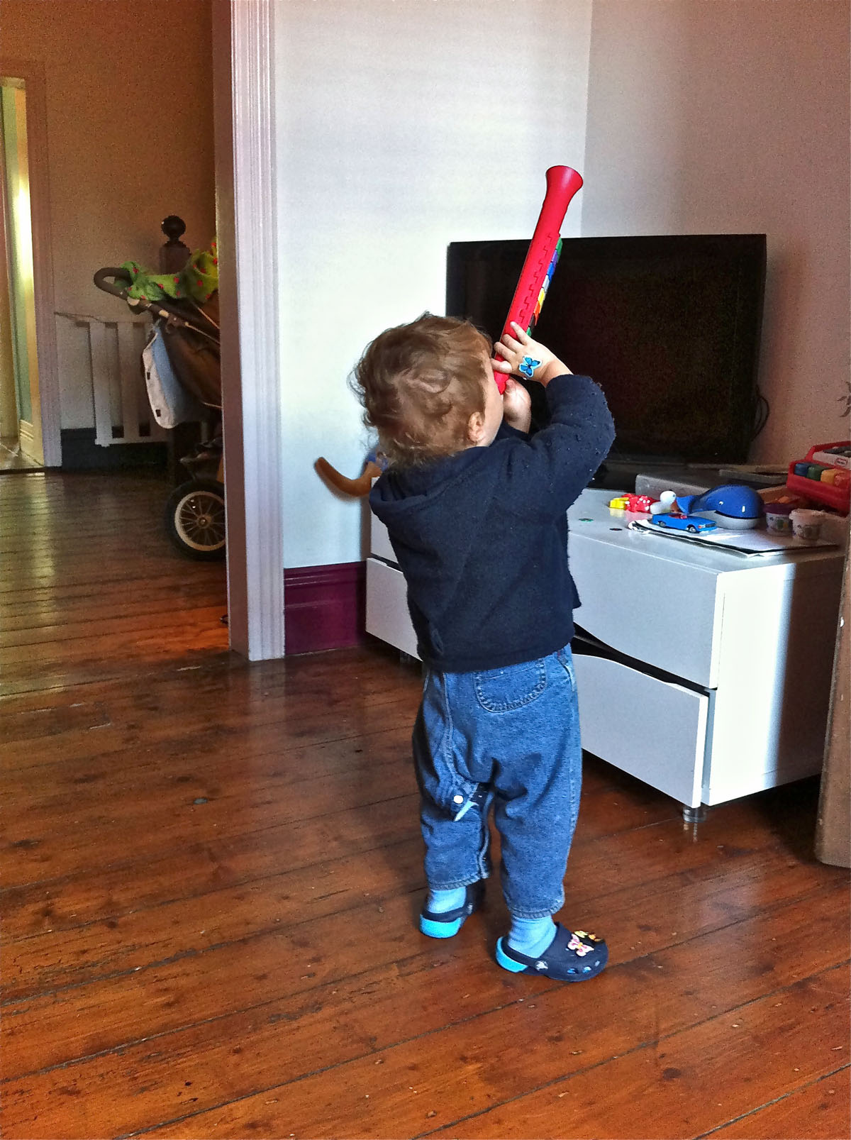 a  with a baseball bat stands in the living room