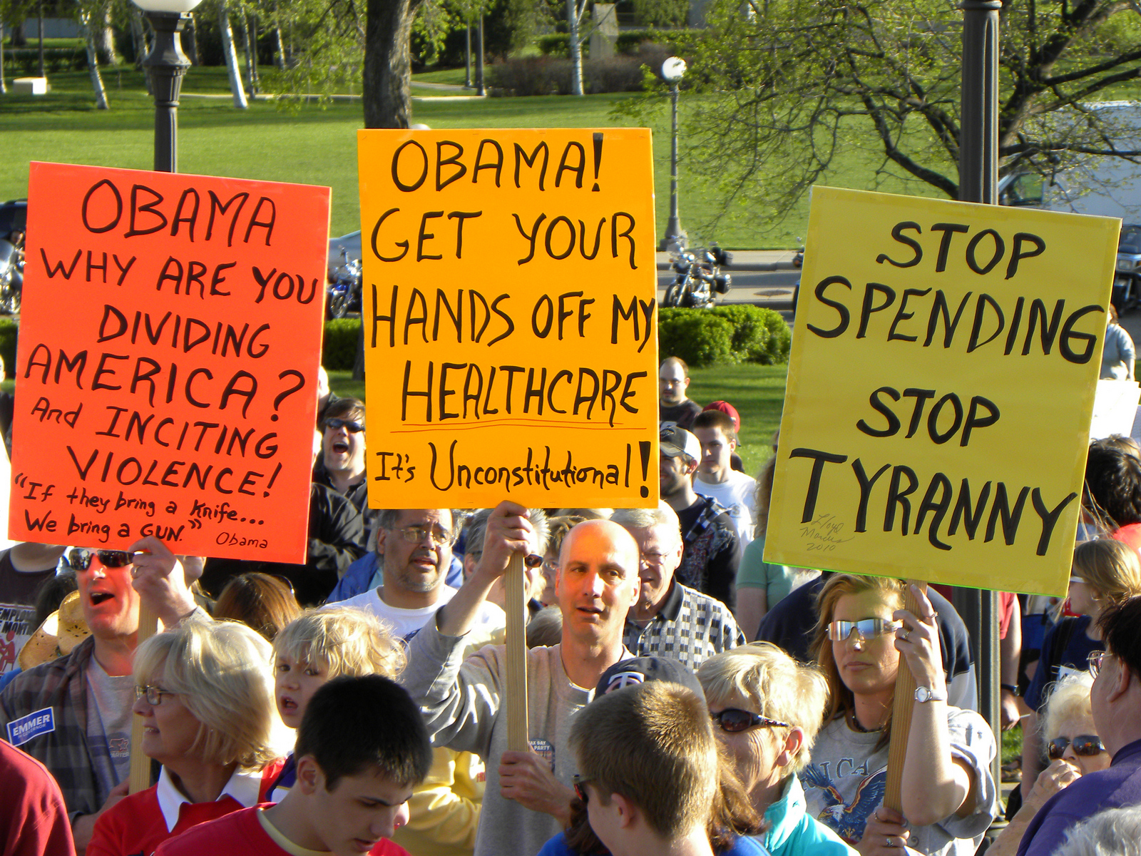 people standing in a crowd holding up signs