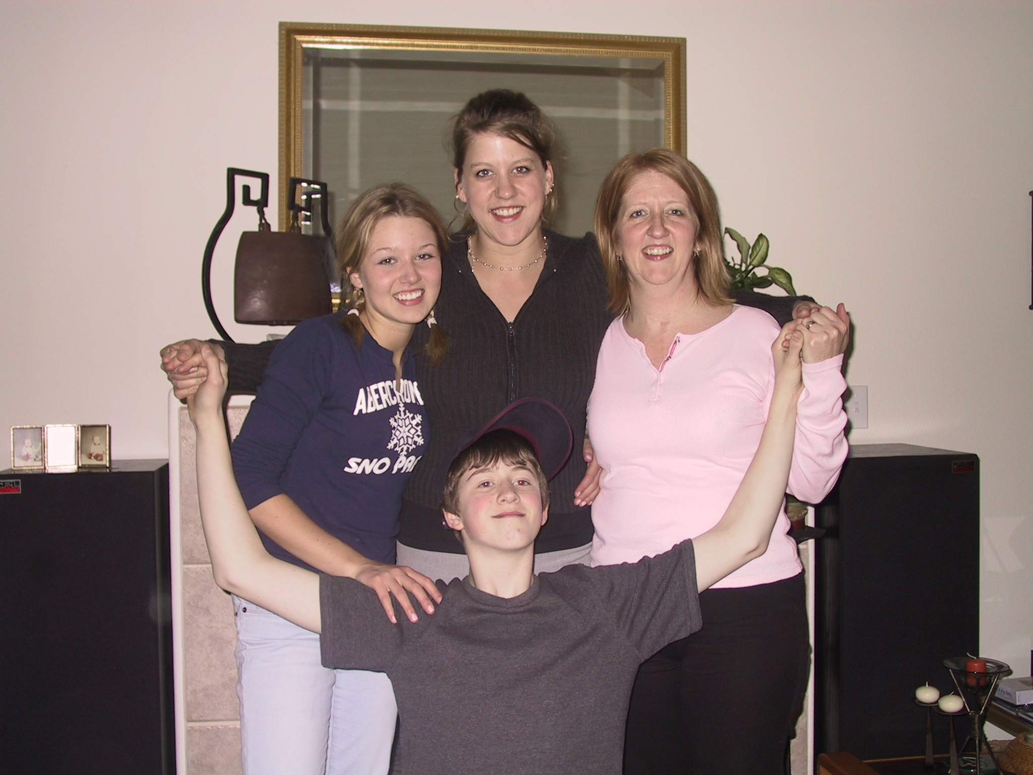 three people posing for the camera with one woman holding the other man's arms in the air