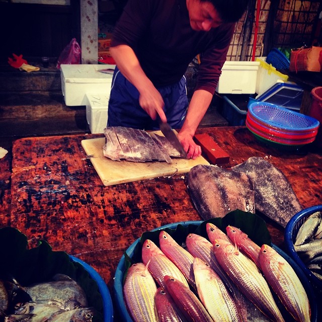 a man is  up fish at a market