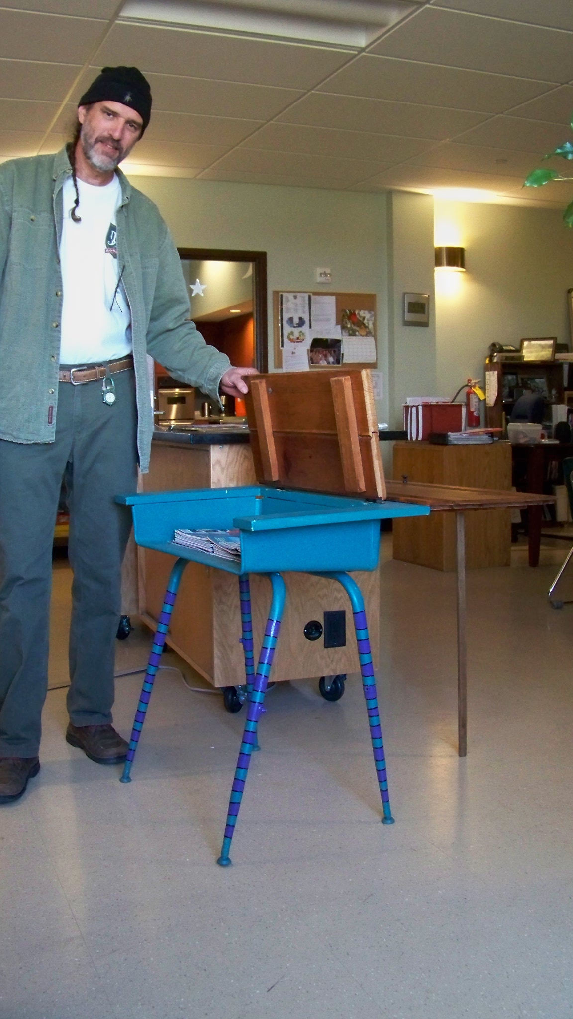 a man standing next to a table that's painted blue