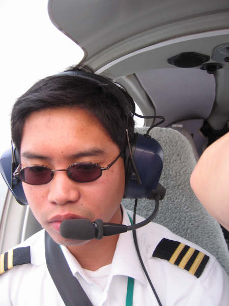 a man in sunglasses and pilot uniform sits in a small airplane