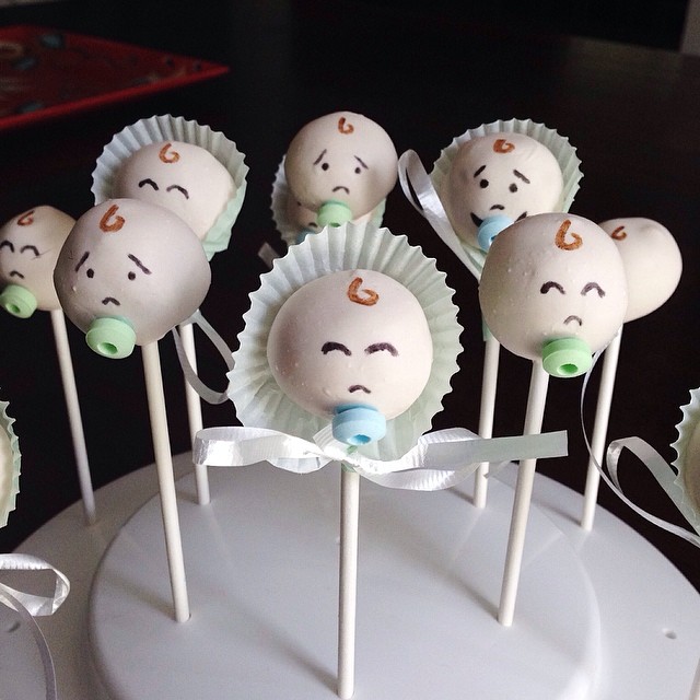a bunch of cake pops with faces painted on them