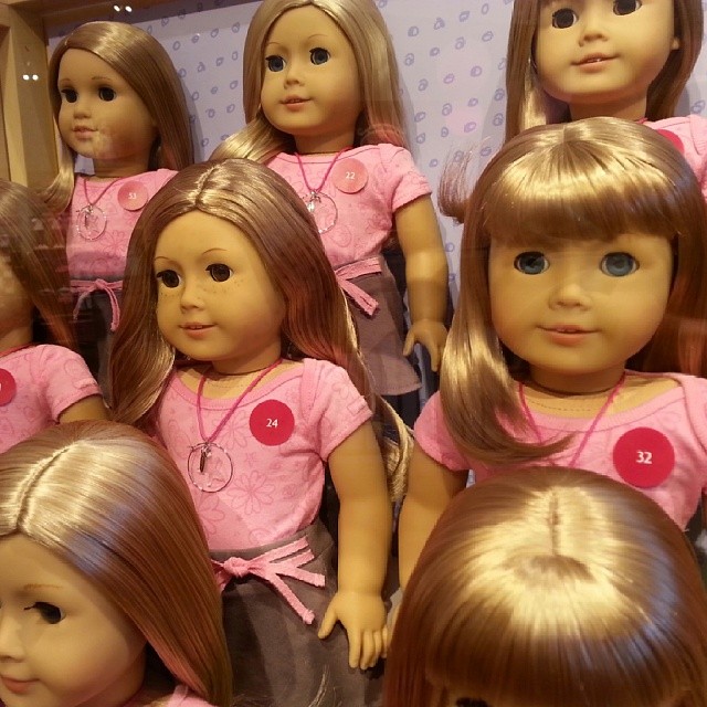 many different dolls wearing different clothes, but all have different facial expressions