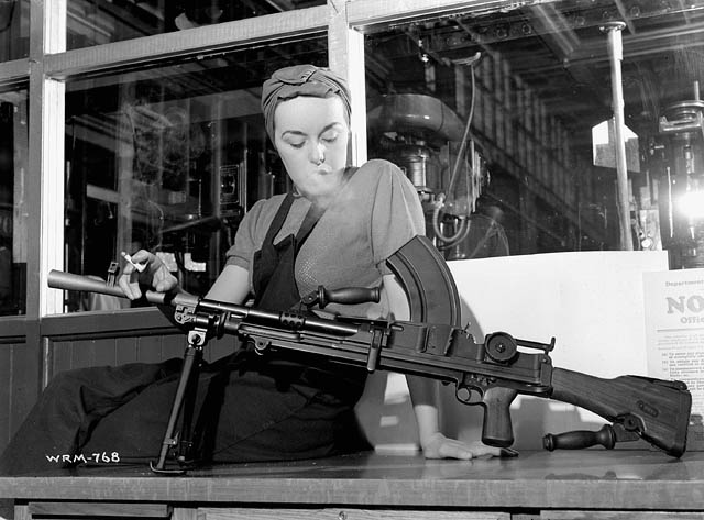 a woman holding a gun in a factory
