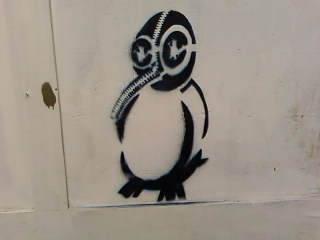 a large black and white penguin on a white wall