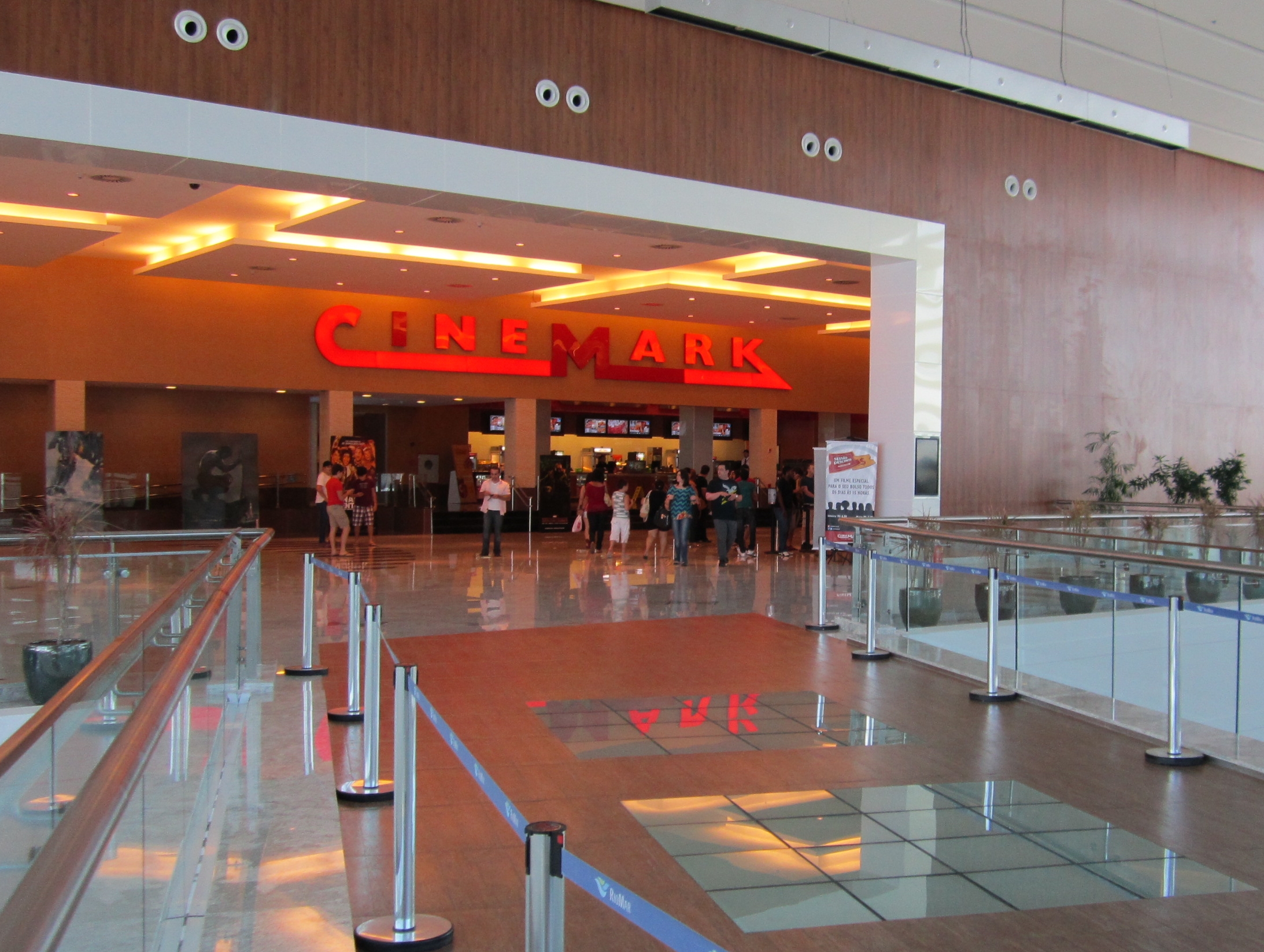 the entrance to a movie shop in a mall with many people