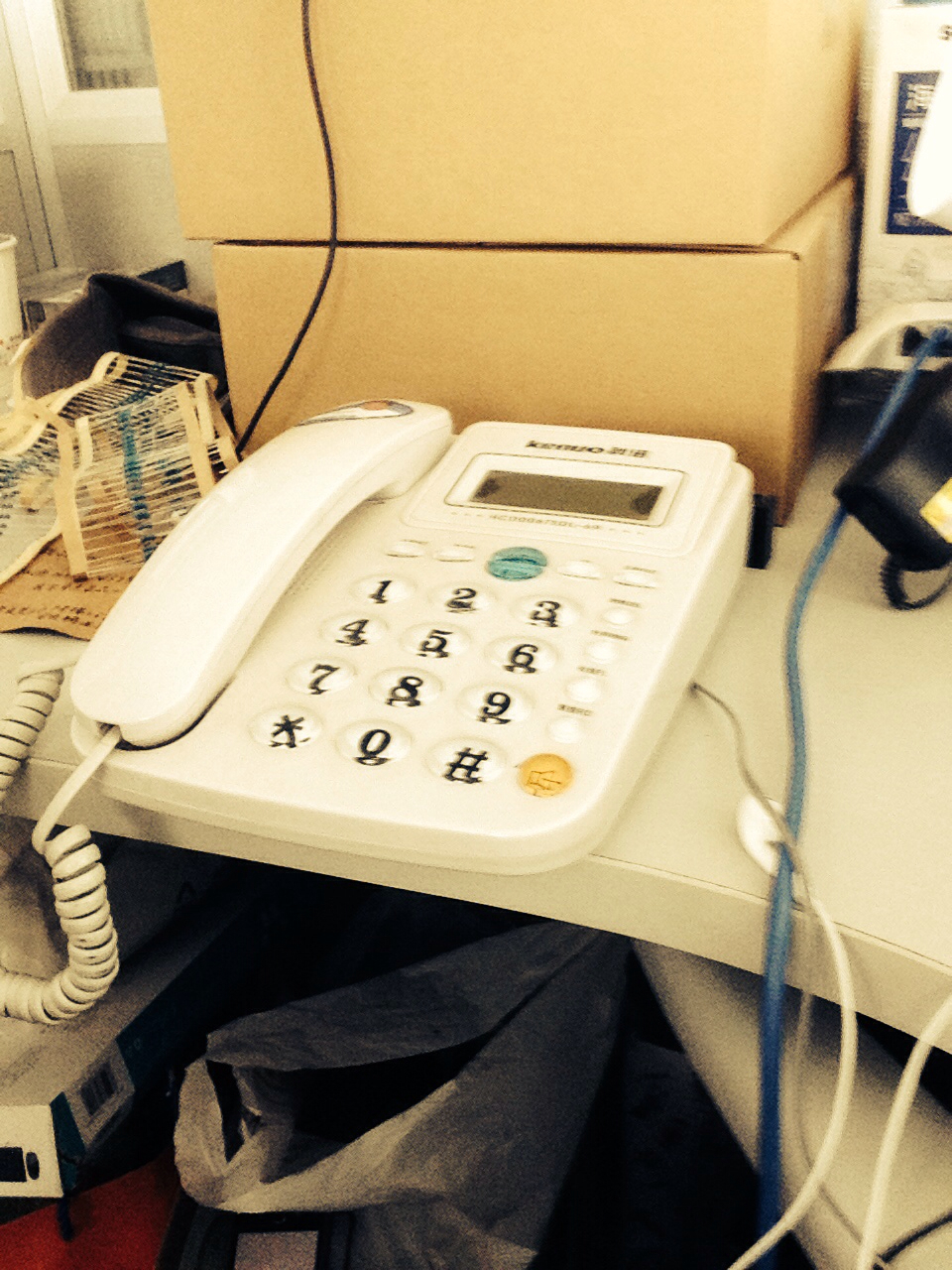 telephone with cords and papers on a desk