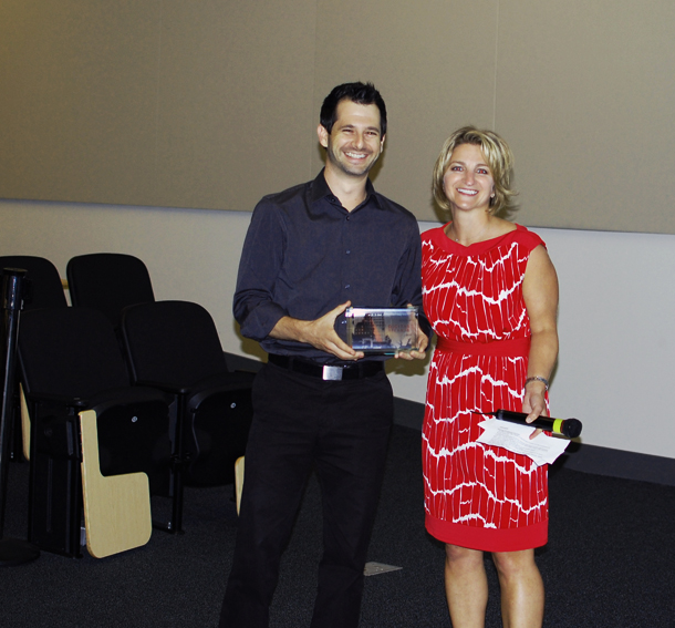 a man holding a silver plaque and standing next to a woman