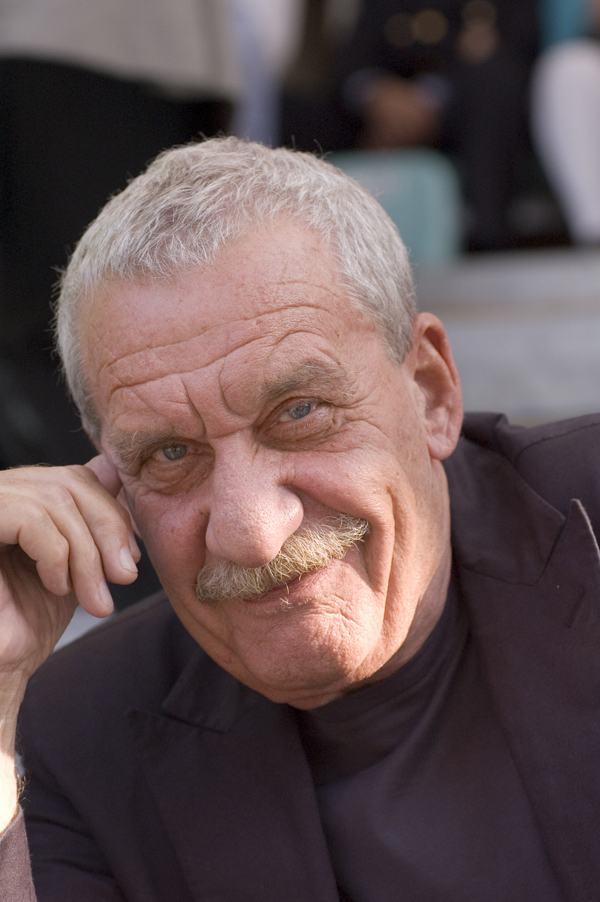man with a mustache and ring sitting down
