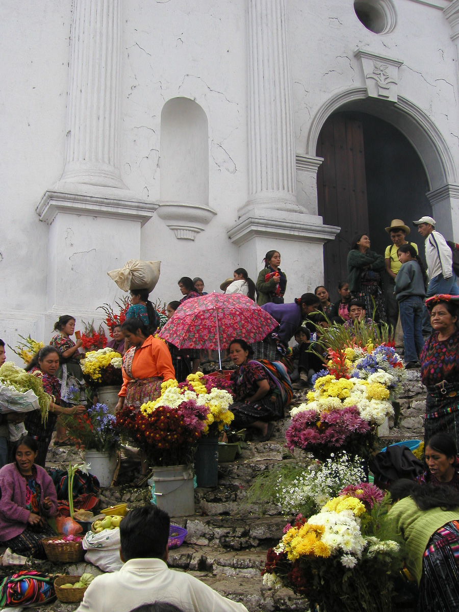 a group of people sitting in front of a white building