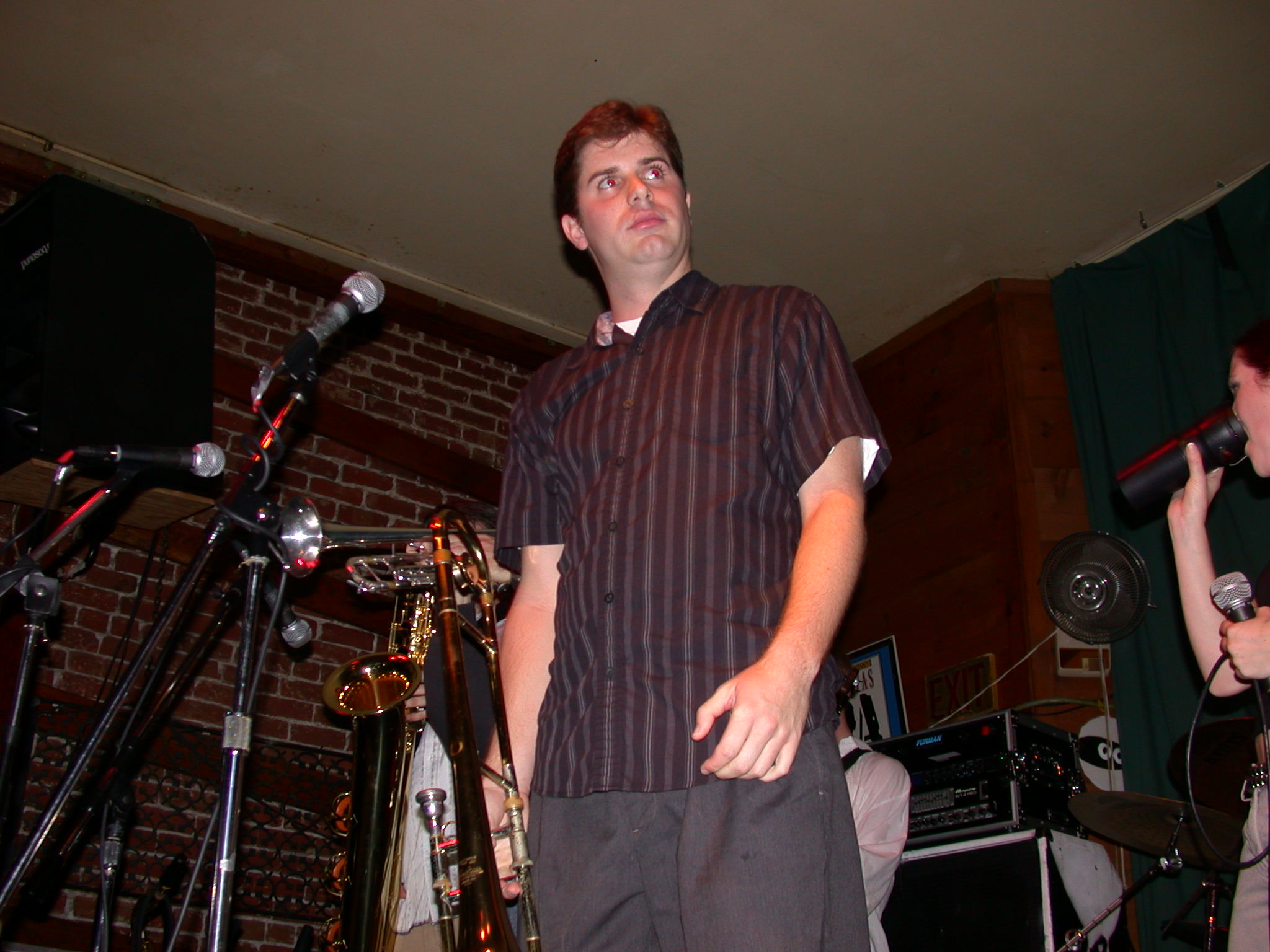 a man in a shirt is standing near some microphones