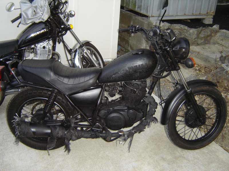 an old motorcycle sitting outside of a building